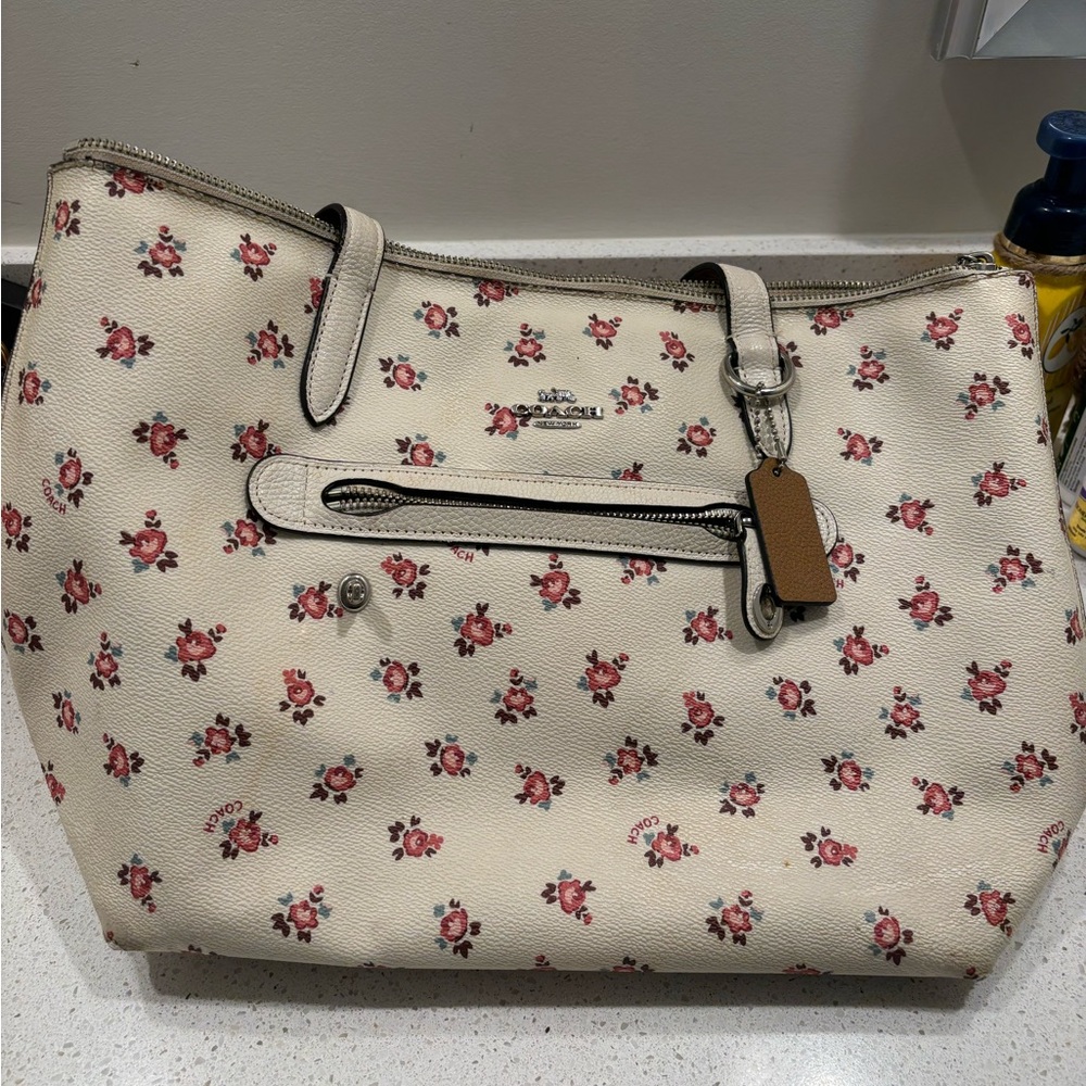 Coach cream purse with mauve flower design. Was gifted and in used condition.